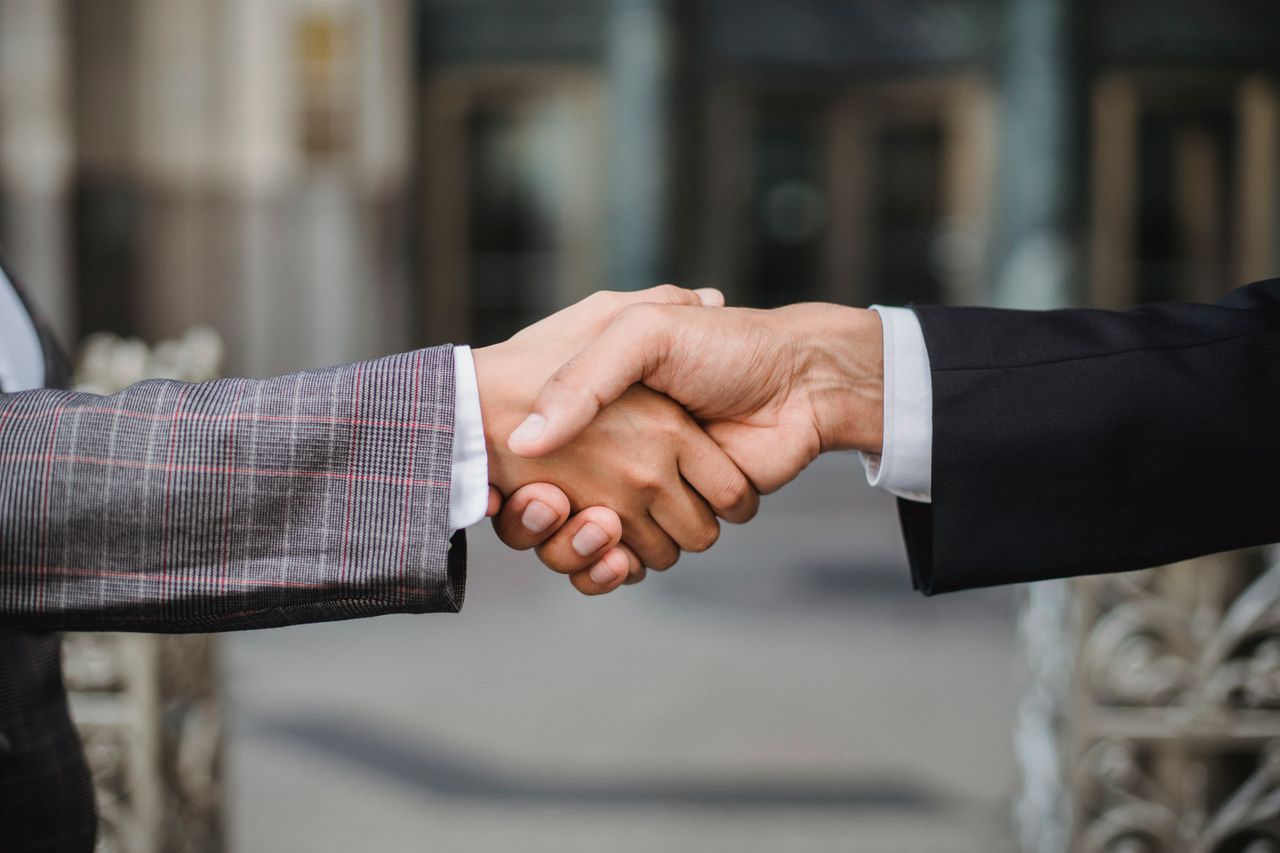 collection-01 A close-up of two businesspeople shaking hands, symbolizing cooperation and partnership.